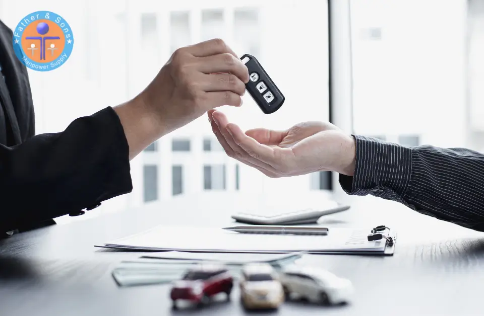 A sales representative handing over key of car to client, making successful sale deal.